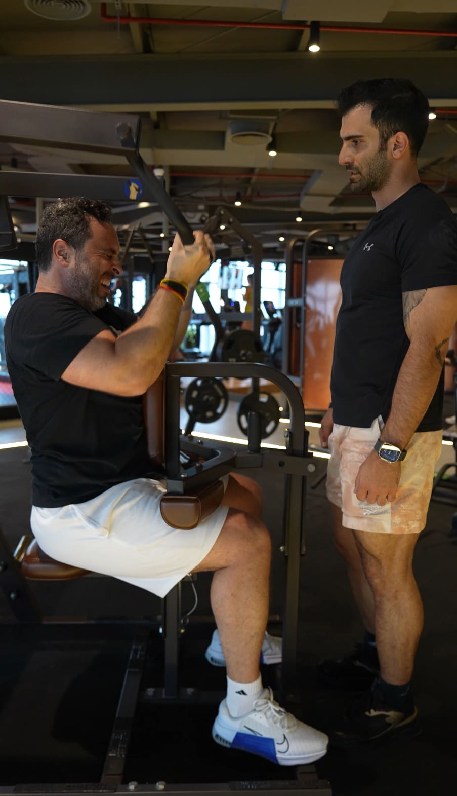 Project Reshape coach spotting a client through a chest press set