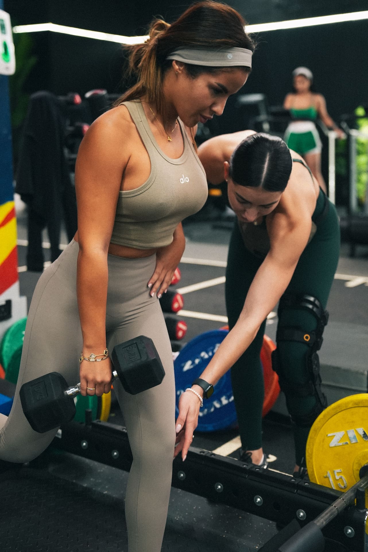 Coach guiding a client through a single-arm dumbbell row